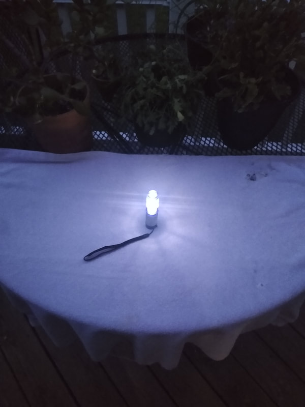Flashlight sits upright on a towel spread over a table